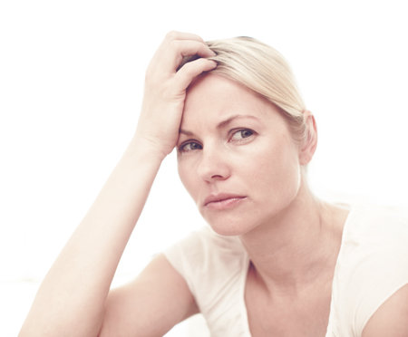 Woman, sad and thinking in studio for mental health, brain fog and depression. Person, trauma and stress on white background with anxiety, regret and doubt with difficult decision or life choiceの写真素材