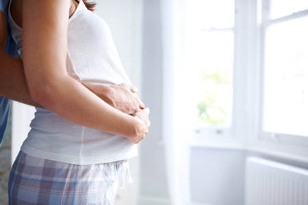 Couple, embrace and pregnancy with stomach, hands and bonding in home for future motherhood support. People, hug and healthy pregnant development for prenatal care, maternity and growth with relaxの写真素材