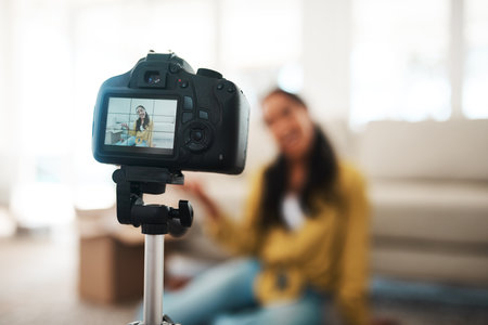 Woman, content creator and home with digital camera for podcast, vlogging and recording video. Female person, apartment and living room as influencer with live screaming, broadcast and internetの写真素材