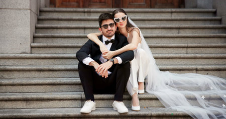 Wedding, city and couple portrait on steps at courthouse with bride, love and modern fashion for celebration. Sitting, people and marriage event for commitment, loyalty and trust with sunglassesの写真素材