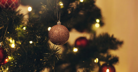 Christmas, tree and ornament ball in home for holiday decoration, vacation and festive tradition. Background, December event and sparkle, shine and lights for detail, aesthetic and party at nightの写真素材