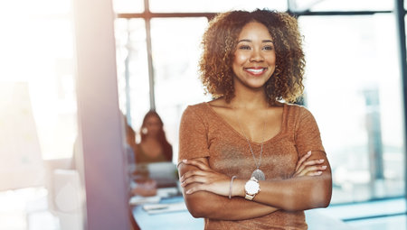 Office, smile and confident African woman with ideas, glass reflection and ambition at creative agency. Happy, workshop and consultant in meeting room with opportunity, thinking and arms crossedの写真素材