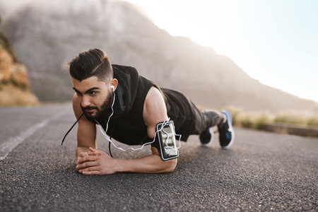 Fitness, nature and man with plank in road for strength, workout and wellness by mountain. Sports, outdoor and male athlete with core exercise for muscle endurance in street for body training.の写真素材