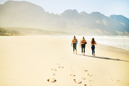 Walking, yoga and back of women on beach for wellness, peace and mindfulness in nature. Morning, pilates and people by ocean for exercise, meditation and workout for health, balance and mobilityの写真素材