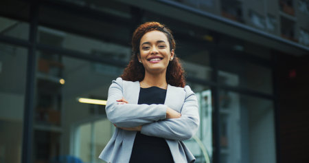 Crossed arms, professional and portrait of businesswoman in town with confidence for finance career. Happy, outdoor and female financial executive from Colombia with pride in morning at urban city.の写真素材