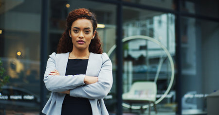 Crossed arms, serious and portrait of businesswoman in city with confidence for finance career. Professional, outdoor and female financial executive from Colombia with pride in morning at urban town.の写真素材