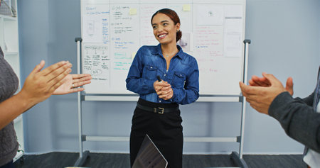 Business woman, whiteboard and applause for presentation, workshop and company development with pitch. Feedback, people and clapping hands for achievement, celebration and proposal success in officeの写真素材