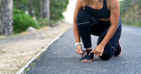 Hands, runner and shoelace on road, outdoor and ready for training, workout or fitness for health in summer. Person, shoes and start morning with exercise, wellness or nature on asphalt in Costa Ricaの写真素材