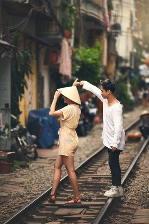 Couple, love and dancing by railway for travel, relationship and holiday adventure with partner. People, freedom and fun in Vietnam for vacation, romance and holding hands on date with train trackの写真素材