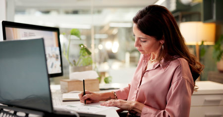 Business woman, office and writing with laptop as web designer for digital agency or company. Female person, technology and analytics for project management, deadline and data report as professionalの写真素材