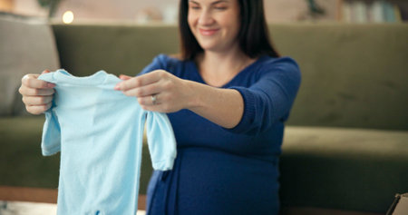 Baby clothes, smile and pregnant woman in living room for unpacking, maternity and shopping for due...