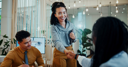 Business people, meeting and handshake for collaboration, agreement or partnership in office. Creative, employees and team discussion with tablet technology, b2b deal and project management goalの写真素材