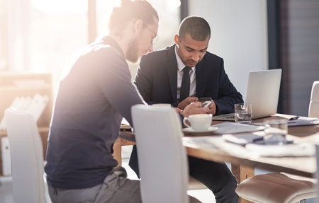 Business, people and typing with phone in office for meeting schedule, communication and review feedback. Men, mobile and lens flare for networking, finance report and reading information of proposalの写真素材