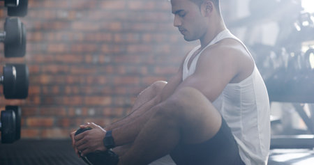 Man, fitness or stretching with feet at gym for workout, exercise or indoor training. Male person,...