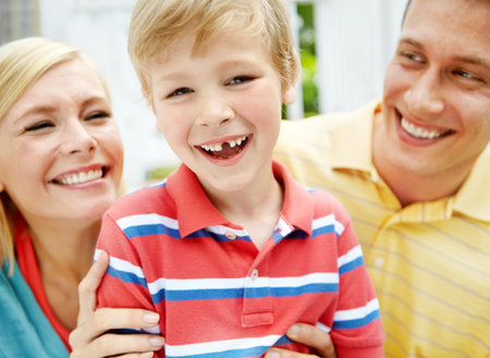 Home, son and smile with parents on outdoor for support, bonding and proud in Canada. People, family and happiness with kid on portrait with break, trust and relax for child growth and developmentの写真素材