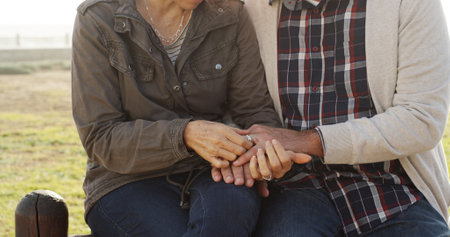 Love, wedding ring and couple holding hands outdoor for commitment, romance or loyalty. Marriage, man and mature woman in nature together for relationship, engagement and valentines day celebrationの写真素材