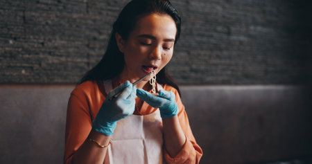 Ramen, eating and Asian woman in restaurant to taste dinner, supper and lunch in cooking class. Culinary, customer and Japanese person with chopsticks for noodles, gourmet dish or traditional cuisineの写真素材