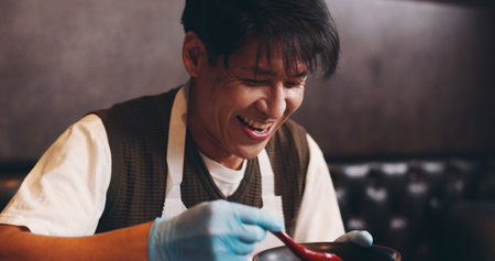 Japanese, man and smile for food in restaurant, lunch and prepare dish with happiness for dinner. Proud, customer or satisfied with soy sauce for noodles, ramen or tsuyu for culinary culture of Japanの写真素材