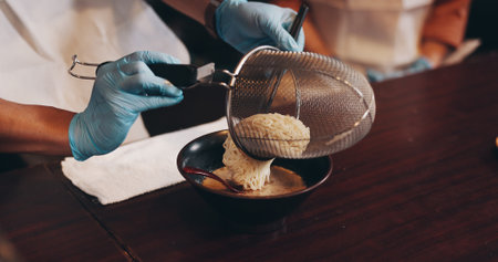 Hands, bowl and meal prep for ramen noodles, cooking class and chef in Japanese restaurant for lunch. Woman, man and serving dish as customer for hospitality, diet and healthy food for culinary skillの写真素材