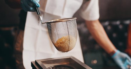 Cooking, hands and steaming noodles in strainer for traditional cuisine, culinary culture and meal preparation. Person, gloves or boiling ramen for nutrition, healthy dinner or lunch in Japanese cafeの写真素材