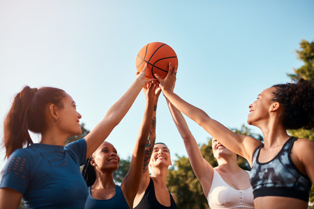 Sports, hands and people with ball in huddle for fitness, support and motivation in outdoor games. Basketball, women and group of female athletes on court for practice match, exercise or trainingの写真素材
