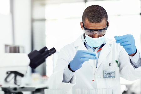 Man, scientist and blood sample at laboratory with mask, test tube and study for mpox vaccine trial. Person, liquid and container with thinking, ppe and safety with chemical, medicine and solutionの写真素材