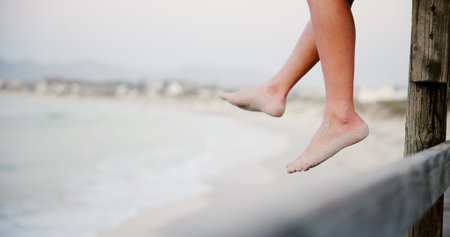 Person, legs and beach sand for vacation, travel and outdoor for peaceful waves in nature. Feet,...