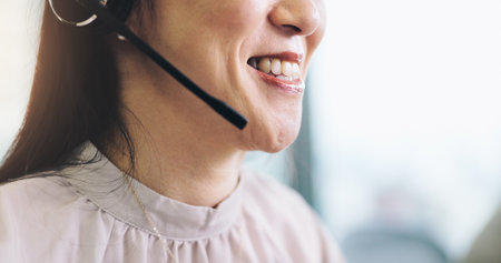 Woman, call centre and mouth in office, representative and customer service in Japan. Female person, telemarketing and global guide for technical support, consulting and agent for helping in closeupの写真素材