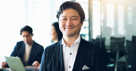 Portrait, Japanese businessman and pride in office for teamwork, collaboration and networking. Male person, happy and meeting as project manager for architecture firm with confidence, smile and staffの写真素材