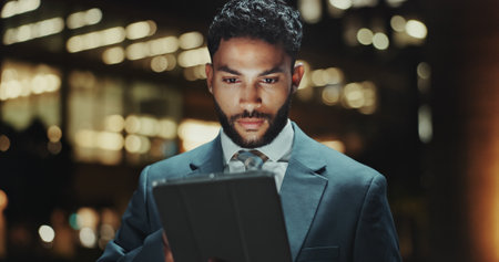 Businessman, tablet and night with city, accountant and internet for project budget. Overtime, planning and information for finance with downtown, research and online communication for website agencyの写真素材