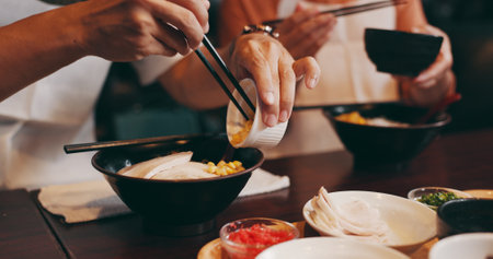 Couple, hands and eating with chopsticks in restaurant for healthy meal, ramen bowl and serving corn vegetables. Japanese people, noodles and food for traditional cuisine, lunch diet and gourmet dishの写真素材
