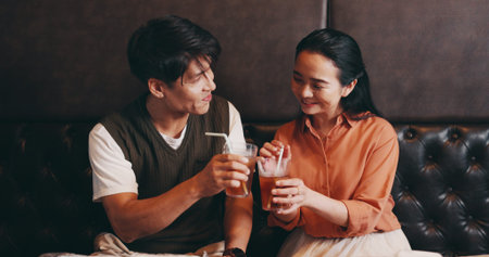 Japanese, couple and drinks in restaurant for cheers, anniversary celebration or love in...