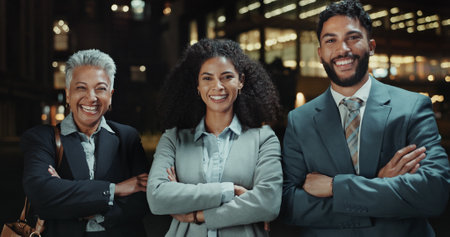 Portrait, night and business people with arms crossed, teamwork or cooperation with smile. Employees, coworkers or lawyers with happiness, buildings or pride with attorney, collaboration or legal aidの写真素材