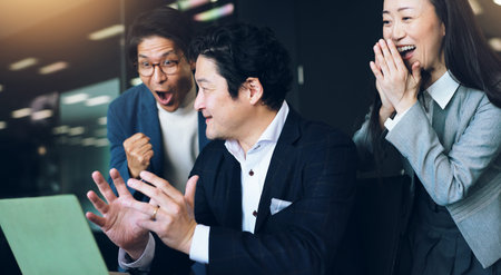 Success, applause and business people with laptop, surprise and achievement with b2b deal. Group, happy employees and coworkers in office, congratulations and clapping with smile, pc and Japanの写真素材