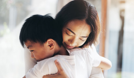 Japanese, mother and hug son at house with love, care and bonding together for childhood development. Smile, woman and child with embrace for affection, family relationship and weekend visit in Japanの写真素材