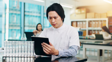 Science, man and tablet with solution in laboratory for research notes, results and exam assessment. Japanese medical university, student and digital report for experiment review and scientific testの写真素材