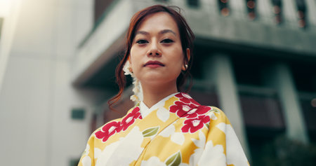 Portrait, kimono and low angle with Japanese woman in city for heritage, festival ceremony and culture. Traditional clothes, fashion and respect with person and Japan outdoor for pride and peaceの写真素材