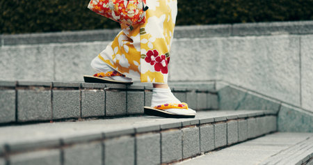 Feet, walking and woman on stairs with kimono, morning commute and traditional clothes in city. Sandals, weekend and girl with Japanese fashion, culture and urban steps on outdoor travel adventureの写真素材