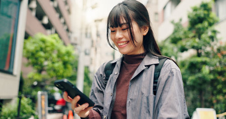 Phone, search and online with Japanese woman in city for location, digital map and travel. Social media post, communication and mobile app with person in Japan for meme, connection and adventureの写真素材