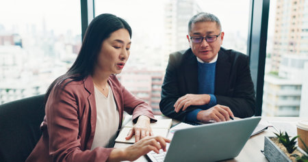 Business people, laptop and collaboration in office for planning, discussion and company financial review. Japan, tech and executive meeting for investment proposal, teamwork and project feedbackの写真素材