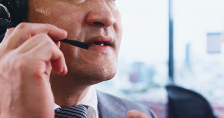Call center, headset or mouth of man in agency for customer service, technical support or consulting. Closeup, microphone or telecom agent for finance advice, conversation and faq feedback in Japanの写真素材