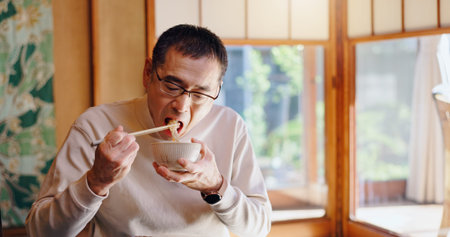 Asian man, eating and food with chopsticks for healthy meal, snack or delicious noodles at home....