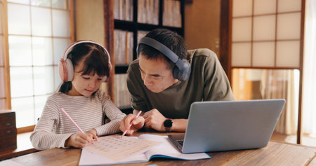 Asian father, daughter and headphones with laptop for online learning, language tutoring or teaching...