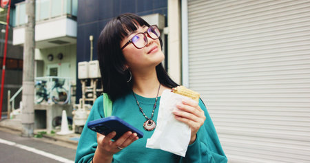 Thinking, student and woman with smartphone, snack and ideas for exam, eating and campus. Outdoor, education and Asian person with food, contemplating and mobile with schedule, smile and Japanの写真素材