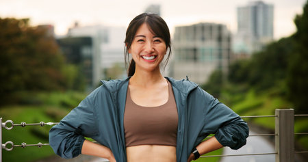 City, fitness and portrait of Japanese woman outdoor for cardio or marathon training routine. Bridge, exercise and smile of happy sports athlete or runner in Japan for challenge, health or wellnessの写真素材