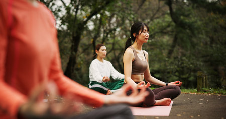 People, outdoor fitness and lotus at yoga class, meditation and support women for spiritual wellness. Forest, holistic healing and instructor for peace in Japan, friends group and zen mindfulnessの写真素材