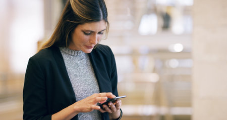 Business, woman or scroll with phone in office for checking notifications, social media app or website information. Professional, person or smartphone for online networking, reading email or researchの写真素材