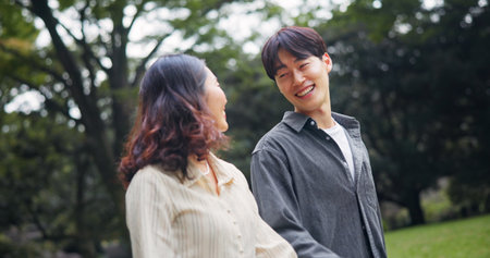 Japanese couple, smile and walk at park for holiday, support or healthy relationship together. Asian man, woman and travel on date at garden outdoor for romantic connection, love or happy on vacationの写真素材