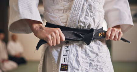 Person, hands and black belt for karate with exercise, ready and prepare for training in Japan...