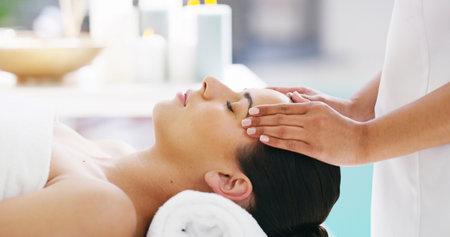 Woman, facial and hands with masseuse for massage, spa treatment or relaxation at luxury resort. Closeup, female person or therapist with client for lymphatic drainage, stress relief or zen at salonの写真素材